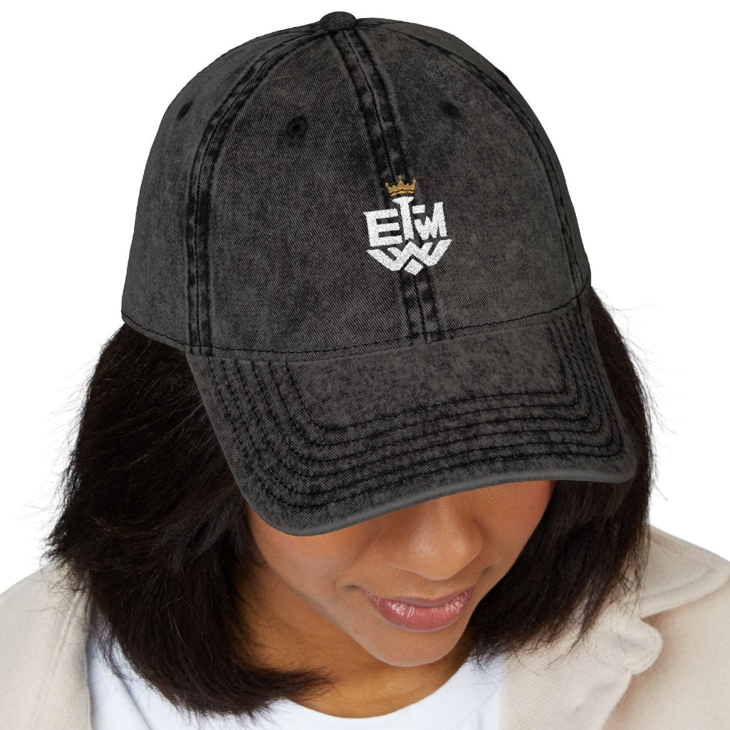 Person wearing a black cap with 'IEWM' text on a white background