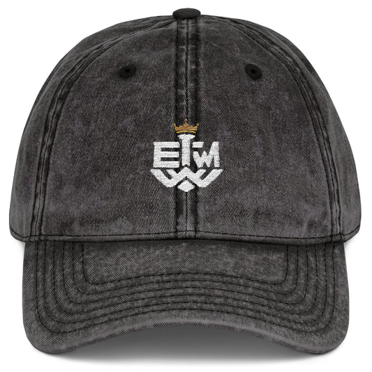 Black distressed cap with 'IEWM' text and gold crown on a white background