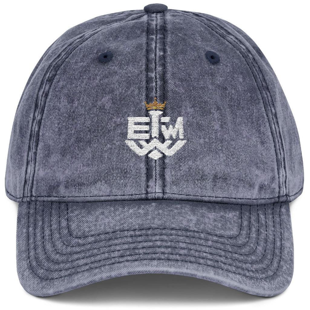 Blue denim cap with 'IEWM' embroidered on a white background