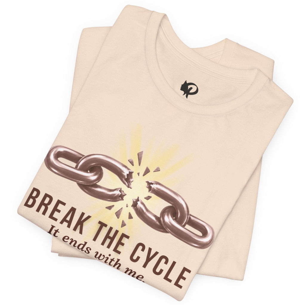 A folded light beige t-shirt with a graphic of a broken chain and the text 'BREAK THE CYCLE It ends with me' printed on the front, set against a plain white background.
