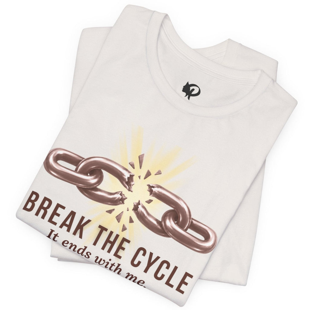 A folded white t-shirt with a graphic print of a broken metallic chain and the text 'BREAK THE CYCLE It ends with me' in brown, displayed on a clean white background.