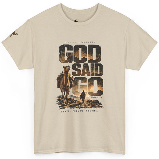 A beige crewneck t-shirt featuring a large graphic print on the front with the text 'GOD SAID GO' in a desert landscape design with a camel and a person, by Prayility Apparel.