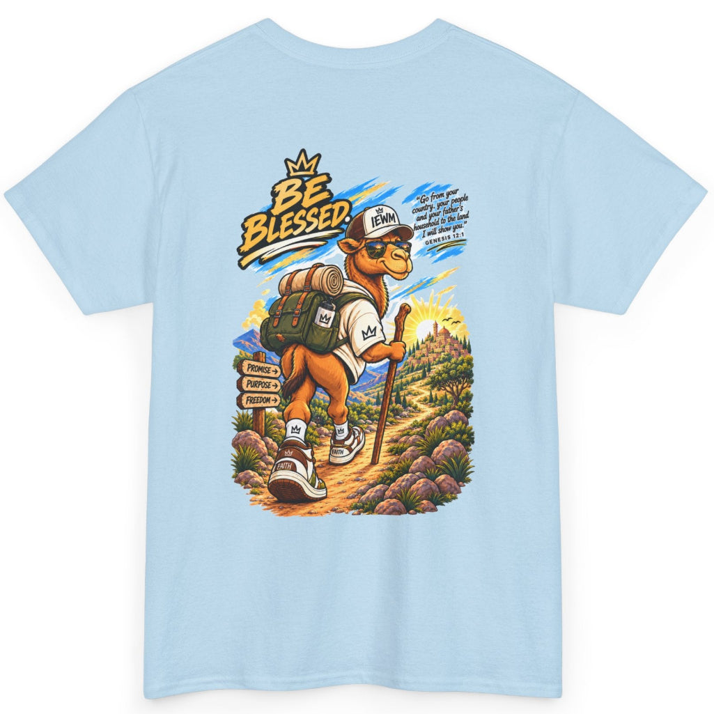 A light blue crewneck t-shirt featuring a colorful graphic print of a cartoon camel wearing a baseball cap and backpack, hiking with the text 'BE BLESSED' and a scripture on a white background.