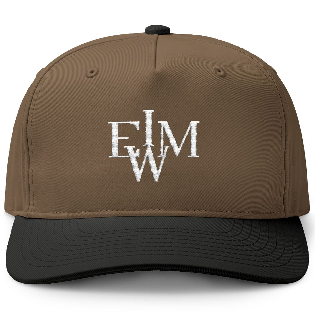 A structured baseball cap with a brown crown and a black curved brim, featuring a white embroidered monogram logo on the front.