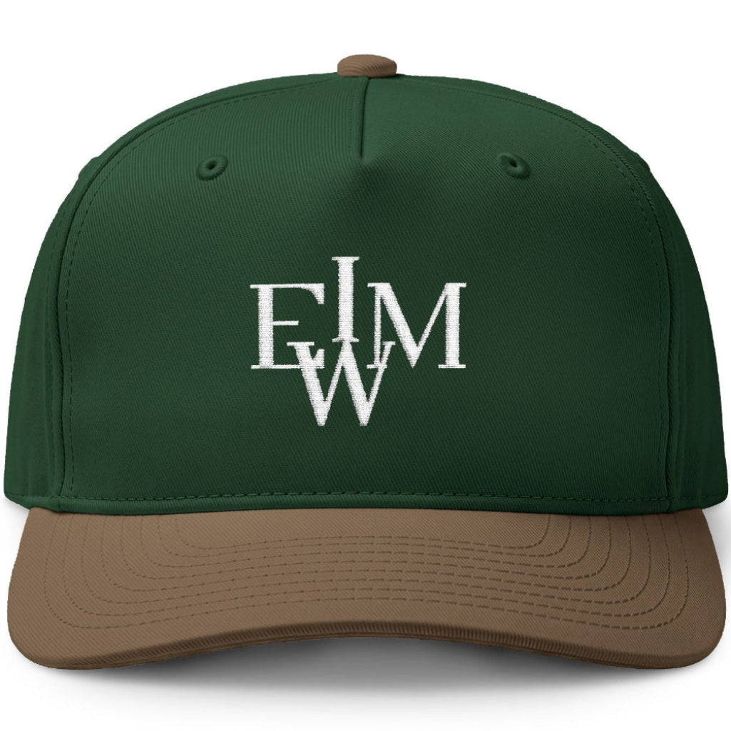 A structured baseball cap with a dark forest green crown and a brown visor, featuring a white embroidered monogram logo on the front.